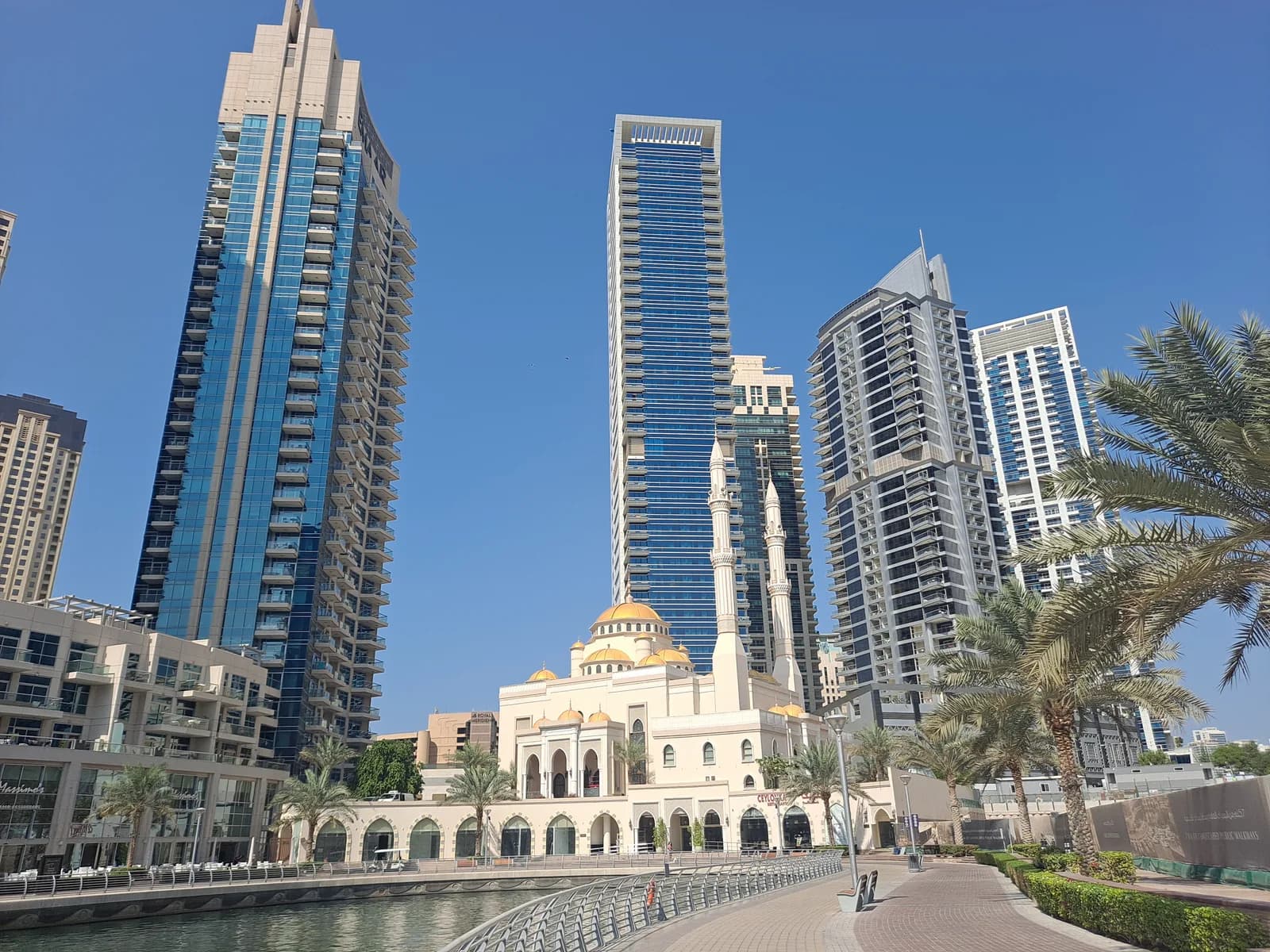 Apartment towers and a mosque beside the pedestrian promenade in Dubai Marina